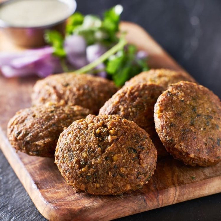 tasty falafel pieces on wooden bread board